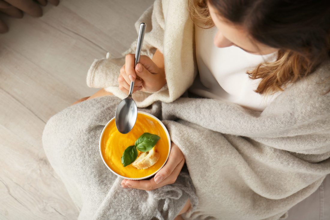 Bird's eye view of woman eating soup, used on blog titled 5 Meal Ideas to Keep You Warm